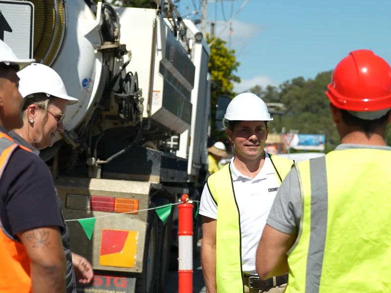 Traffic management team coordinating roadside operations beside construction and service vehicle