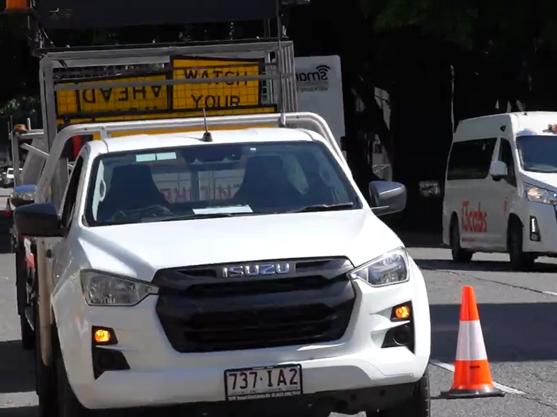 Traffic management vehicle positioned beside roadside safety cone during active roadwork operations