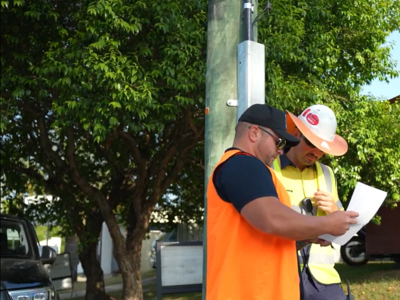 Traffic management workers reviewing site documents during roadside inspection and coordination